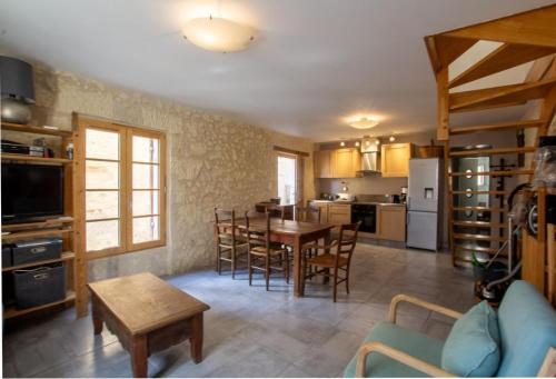 une cuisine et une salle à manger avec une table et des chaises dans l'établissement La maison de famille, à Mussidan