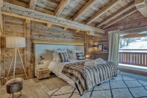 a bedroom with a bed and a wooden wall at Chalet des rêves in Megève