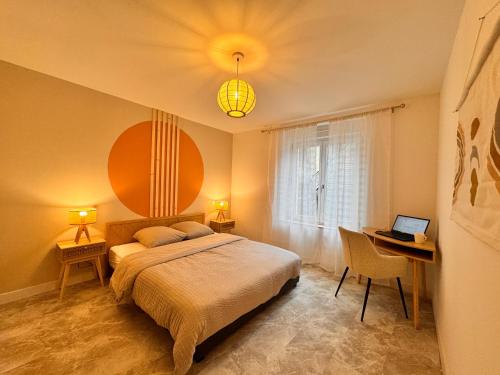 une chambre avec un lit et un bureau avec un ordinateur portable dans l'établissement Le Jardin Japonais Épinal avec terrasse, à Épinal