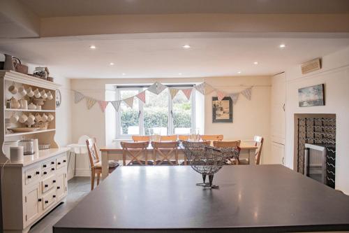a kitchen and dining room with a table and chairs at Bantham House, Bantham, South Devon - a few steps from golden sandy beaches in Bantham