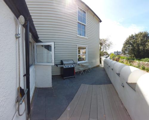 a porch of a house with a wooden deck at Bantham House, Bantham, South Devon - a few steps from golden sandy beaches in Bantham