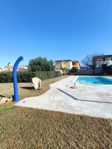a pool with a blue pipe next to a yard at Perla in Torpè
