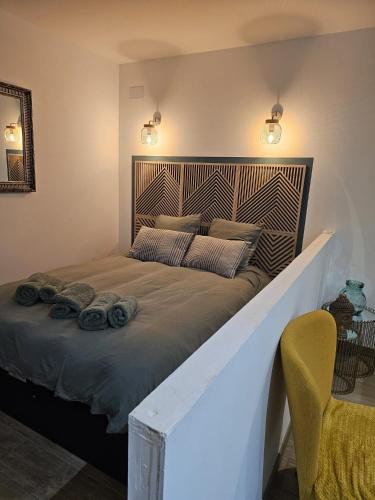 une chambre avec un grand lit avec une tête de lit en bois dans l'établissement La Dame - Parking privé - Proche GE Alstom, à Cravanche