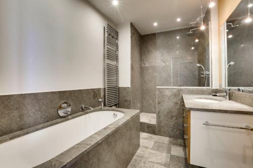 une salle de bain avec une baignoire, une douche et un lavabo dans l'établissement REINE - Vue imprenable Grande Plage, à Biarritz