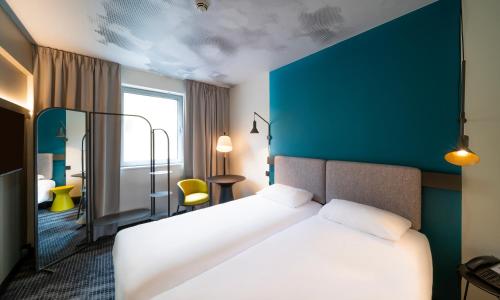 a hotel room with a bed and a blue wall at Ibis Praha Wenceslas Square in Prague
