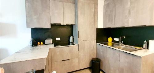 une cuisine avec des armoires blanches et un évier dans l'établissement O'Cap, à Antibes