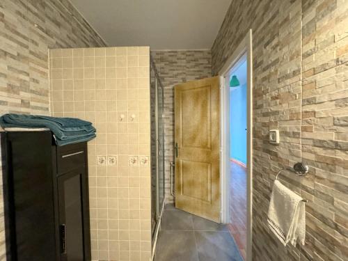 a bathroom with a shower and a wooden door at La Canaleja in Candeleda