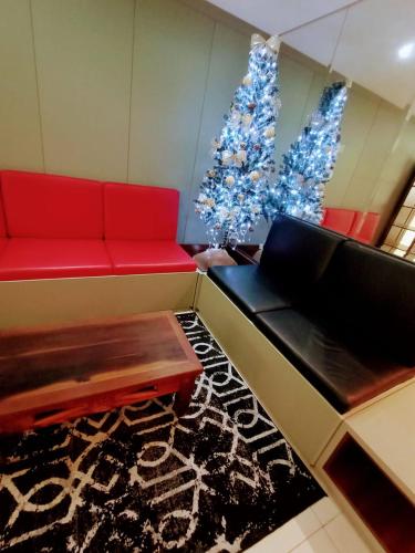 a living room with a red couch and a christmas tree at Dalmo Hotel in Gravatal
