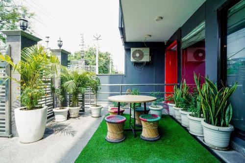 a patio with a table and a bunch of potted plants at Saltstayz Express -Medicity Near Medanta Hospital in Gurgaon