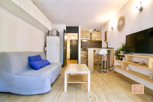 un salon avec un canapé bleu et une table dans l'établissement Le Kanumera, piscine et clim, à La Seyne-sur-Mer