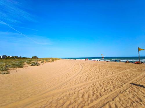 a sandy beach with people flying a kite at Apartamento loft en Castelldefels junto la playa in Castelldefels