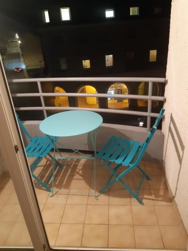 une table et deux chaises sur un balcon dans l'établissement Studio Ax Pyrénées, à Ax-les-Thermes