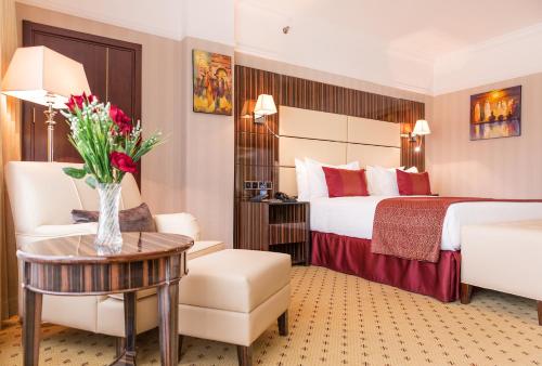 アディスアベバにあるGolden Tulip Addis Ababaのベッドと花瓶が備わるホテルルームです。