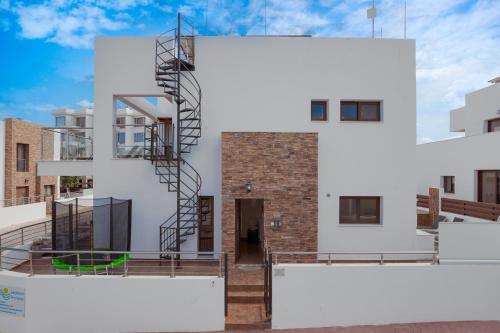 a building with a spiral staircase on the side of it at Seafront Protaras Villas in Protaras