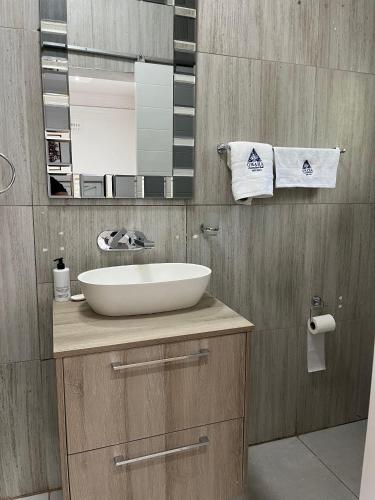 a bathroom with a sink and a mirror at Omaha Luxury B&B & SPA in Mthatha