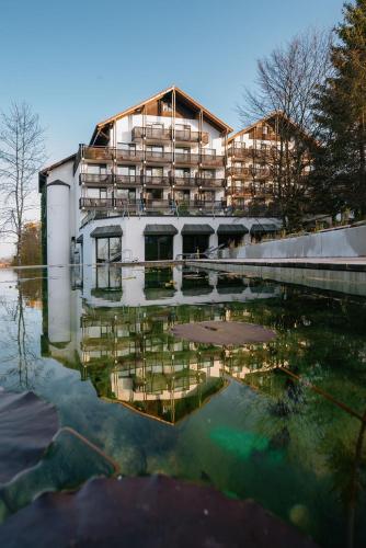 a building with its reflection in a body of water at Villa am Park in Bad Tölz
