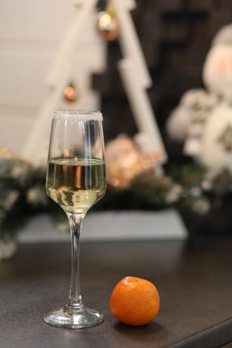 a glass of wine next to an orange on a table at Weekend house in Verkhovyna