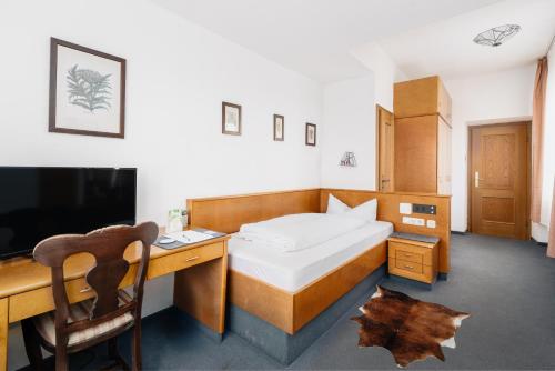 a bedroom with a desk and a bed and a desk and a television at Villa am Park in Bad Tölz