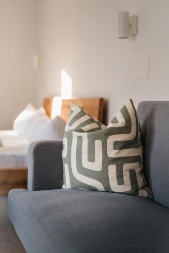 a blue couch with a black and white pillow on it at Villa am Park in Bad Tölz