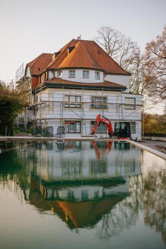 a building with a reflection in a body of water at Villa am Park in Bad Tölz
