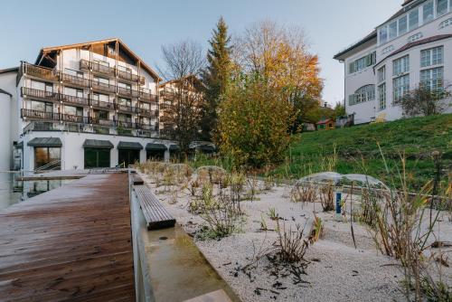 a wooden dock with a bench in front of a building at Villa am Park in Bad Tölz