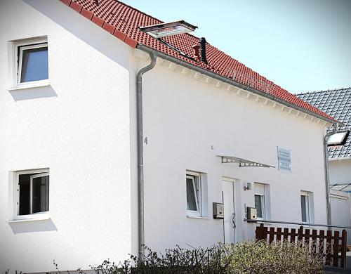 a white house with a red roof at Pension Talhaus-WG Allmersbach in Allmersbach im Tal