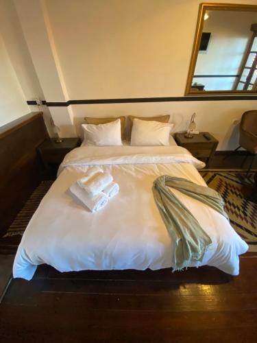 a bedroom with a bed with two towels on it at Pliades Traditional Guesthouse in Palaios Panteleimon