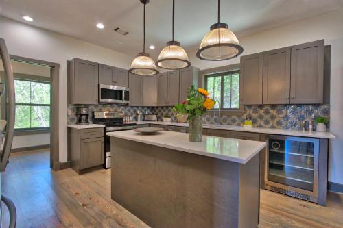 a kitchen with brown cabinets and a island with a vase of flowers at Southwind at The Bend in Wimberley