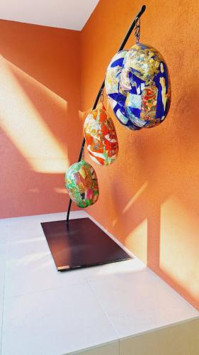 Cette chambre est dotée d'objets colorés en verre accrochés à un mur. dans l'établissement Superbe appartement terrasse piscine vue panoramique mer et montagnes, à Mandelieu-la-Napoule