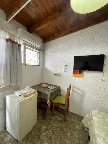 a kitchen with a small table and a refrigerator at Eyo Habitación privada en Chuy con baño Privado No es hostal in Chuy