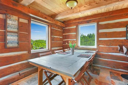 a wooden dining room with a table and two windows at Ozuye Lodge in Fischer
