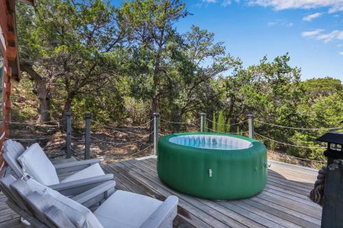 a hot tub on a deck with chairs and trees at Ozuye Lodge in Fischer