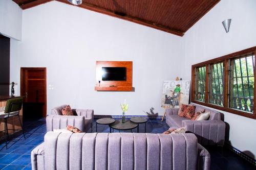 ドゥアラにあるVilla Fernandinoのソファ2つとテレビのあるリビングルーム