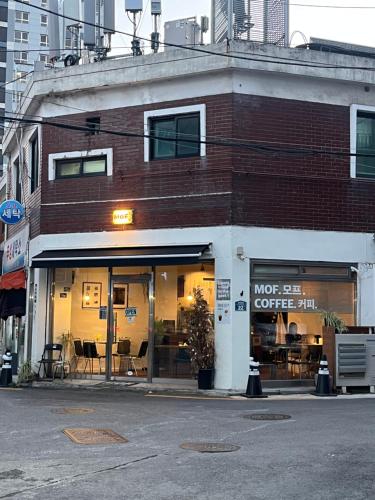 un edificio de ladrillo con una cafetería en una calle de la ciudad en Cozy guesthouse, 10 minutes from SNU Entrance Station, accommodation in Sharosu-gil, OTT, Nespresso machine, within 25 minutes by subway to Hongdae, Gangnam, Seongsu, Gwanaksan, up to 5 people, en Seúl