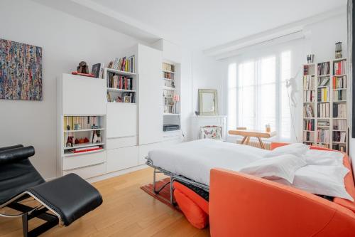 - une chambre avec un lit, une chaise et des étagères dans l'établissement Veeve - Peaceful Gallery, à Paris