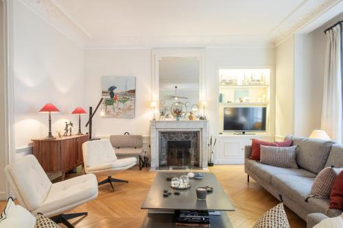 un salon avec un canapé et une cheminée dans l'établissement Veeve - Chic in Neuilly, à Neuilly-sur-Seine