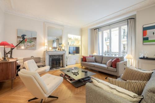 un salon rempli de meubles et d'une cheminée dans l'établissement Veeve - Chic in Neuilly, à Neuilly-sur-Seine