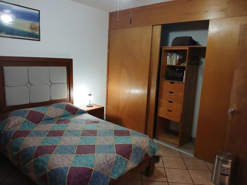 a bedroom with a bed and a dresser at Suites del Centro in Morelia