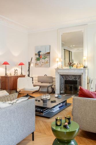 un salon rempli de meubles et d'une cheminée dans l'établissement Veeve - Chic in Neuilly, à Neuilly-sur-Seine