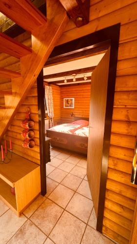a room with a bed in a wooden cabin at Haus Sonnenblick in Arrach