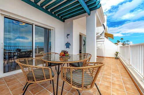 a dining room with a table and chairs on a balcony at Blue apartment with One bedroom, WiFi and amazing view in Chayofa