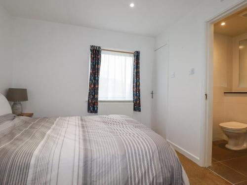 ein Schlafzimmer mit einem Bett, einem Fenster und einem WC in der Unterkunft Catch the Wave in Newquay