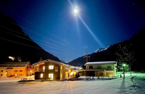 a house in the snow at night with the moon at Woodpecker Chalets in Klösterle am Arlberg