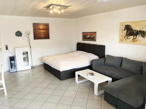 a living room with a bed and a couch at Familien- und Aparthotel Strandhof in Butjadingen OT Tossens