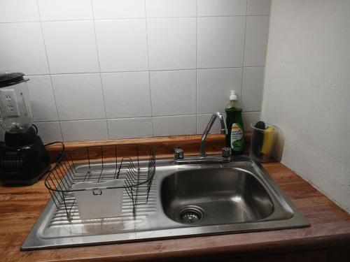 a kitchen sink with a dish drying rack on it at Suites del Centro in Morelia