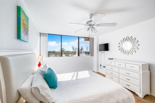 a bedroom with a bed and a ceiling fan at Our House at the Beach 201W by Beachside Management in Siesta Key