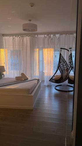 a bedroom with a bed and two chairs and windows at Brandão House in Caparica