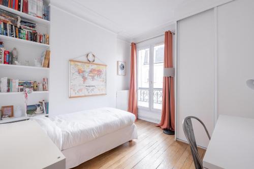 une chambre blanche avec un lit et une fenêtre dans l'établissement Veeve - Cotton White, à Paris