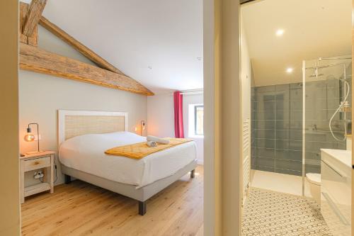 - une chambre avec un lit et une douche dans l'établissement Cuvage des Pierres Dorées - Beaujolais, à Denicé