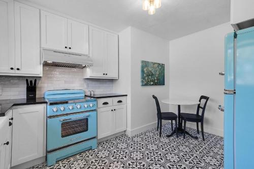 a kitchen with a blue stove and a table at Milk Bath Springs House in Dripping Springs